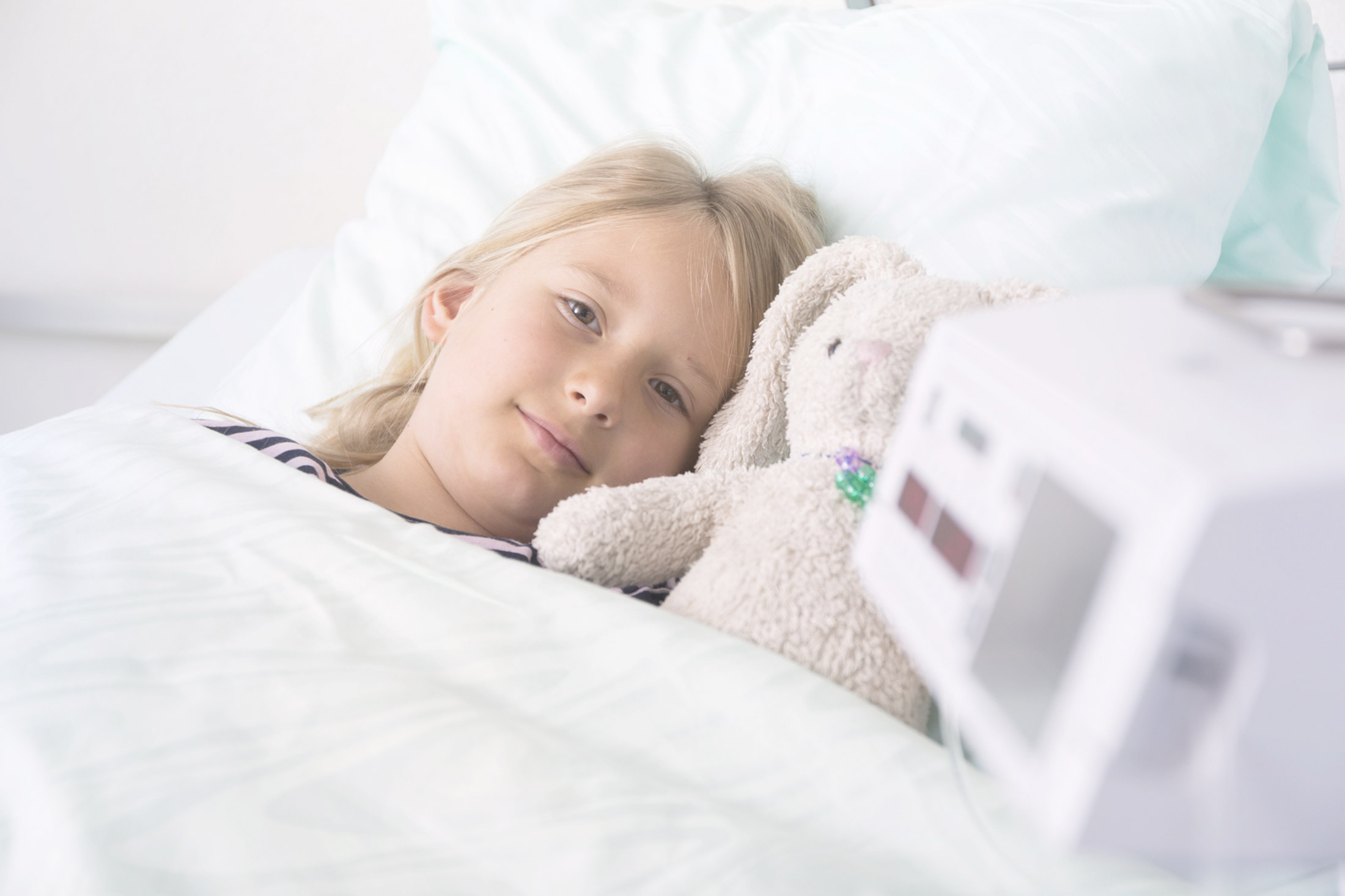 Child with cuddly toy from an infusion pump.